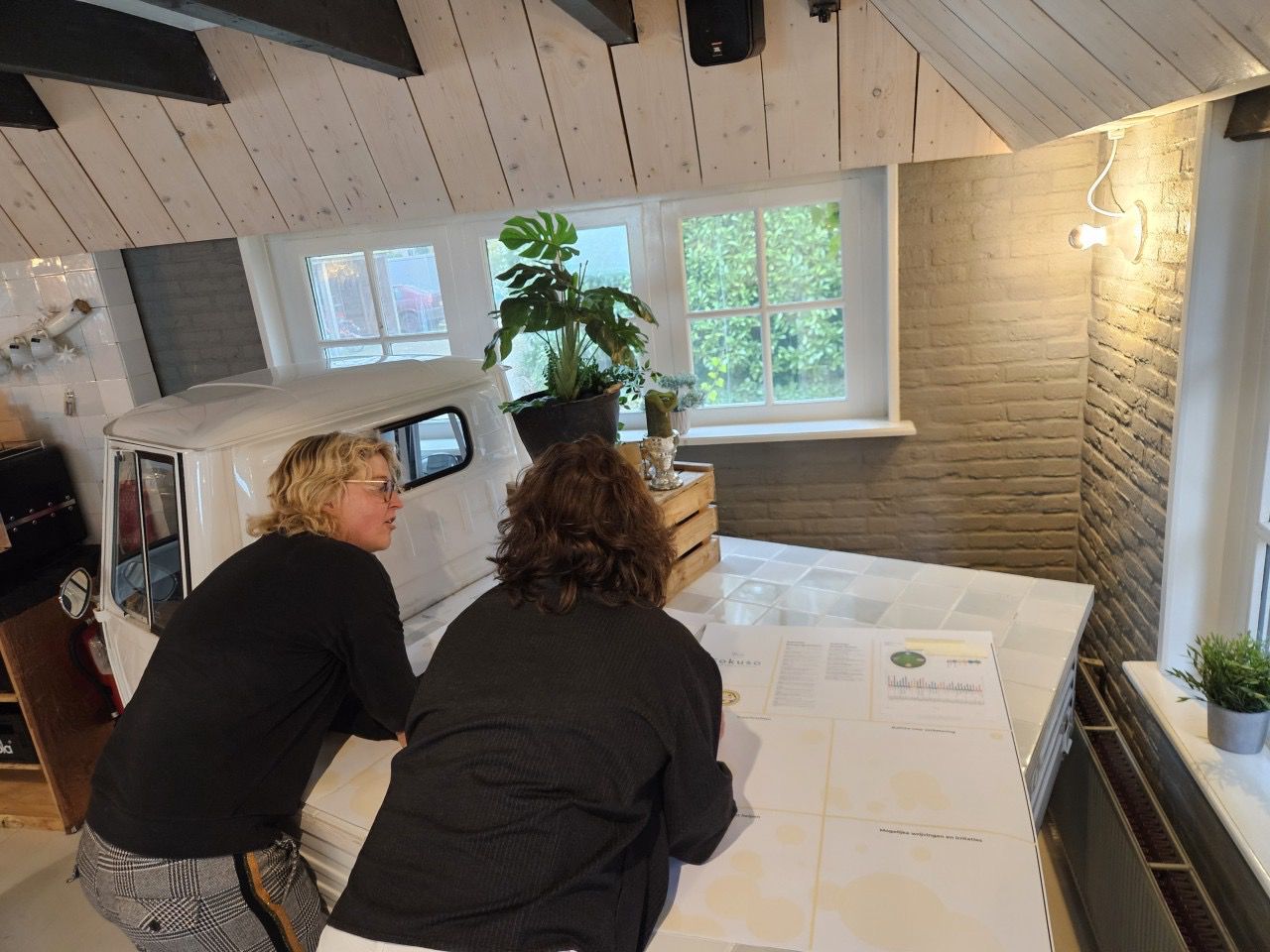 Two team members reading a MindSonar profile together at a long table in the Fokuso studio.